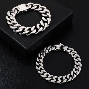 Polished silver men's Cuban link chain bracelets in two sizes on black leather texture