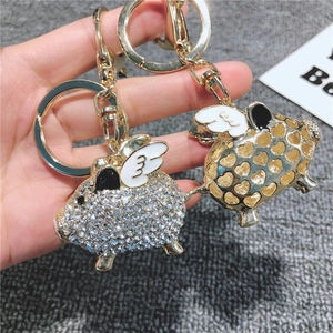 Dettaglio portachiavi a forma di maiale volante dorato con strass e design a cuore