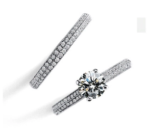 Macro shot of a classic six-prong brilliant-cut diamond solitaire ring with eternity band set
