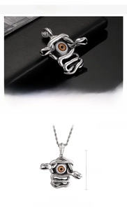 Macro detail of Medusa snake pendant with evil eye in polished stainless steel
