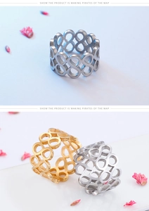 Macro detail of geometric hollow figure-eight rings in gold and silver stainless steel
