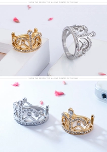 Dettaglio degli anelli a forma di corona in oro e argento con pavé di cristalli lucidi