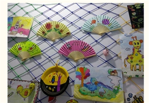 Éventails en papier colorés DIY et créations pour enfants suspendus sur un filet décoratif