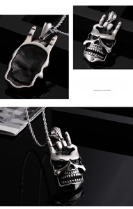 Détail macro du pendentif crâne gothique avec geste rock en acier inoxydable poli