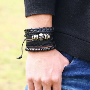 Bracelet multicouche vintage en cuir noir avec crâne, porté par un mannequin en extérieur
