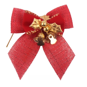 Detail of red mesh Christmas bow with gold bells and velvet leaf for festive DIY decor