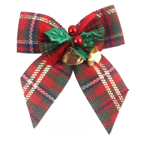 Detail of tartan Christmas bow with gold bells, green leaves and red berries