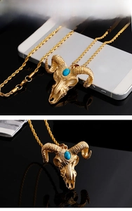 Detailed macro view of golden devil sheep head pendant with blue stone and fine steel chain