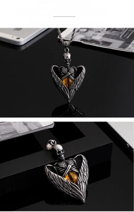 Gothic skull pendant with heart wings and yellow gemstone on twisted rope chain detail