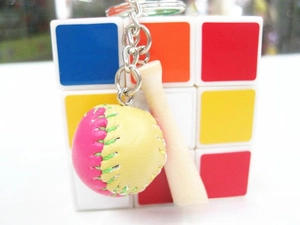 Detail of pink and yellow leather mini baseball with stitching and wooden bat keychain