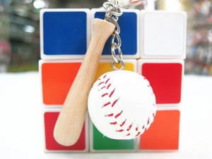Detail of wooden baseball bat keychain with white softball charm and silver chain