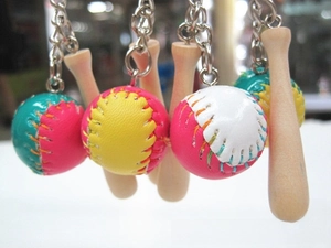 Detail of mini wooden baseball bat and hand-stitched leather ball keychains in various colors