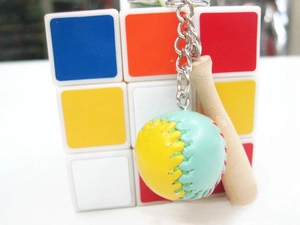 Detailed shot of mini leather baseball and wooden bat keychain accessory for bags