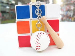 Detail of mini wooden baseball bat and white leather ball keychain with silver ring