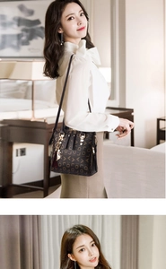 Detail of printed PU leather handbag featuring a cat charm and gold hardware accents