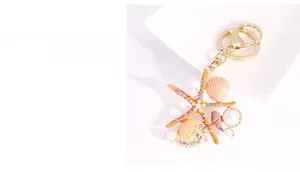 Détail du porte-clés étoile de mer avec coquillage rose, perles et anneau doré