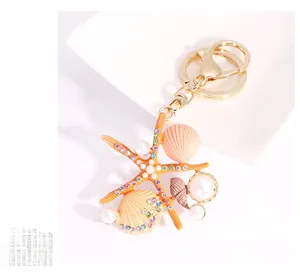 Détail du porte-clés étoile de mer et coquillage avec perles et cristaux sur l'assiette