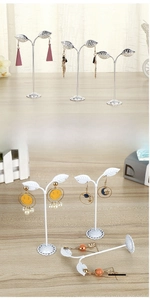 Leaf-shaped metal earring stand detail with multiple holes and a round stable base