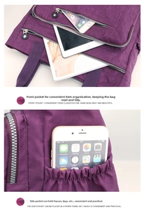 Detail of purple nylon shoulder bag featuring front zipper pocket and side drawstring pouch