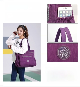 Detail view of large purple nylon tote bag featuring side pockets and sturdy handles