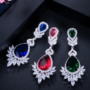 Macro detail of pear-cut sparkling zircon drop earrings in blue, red, and green colors