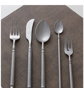 Macro shot of 5-piece matte dark grey stainless steel cutlery set with brushed texture
