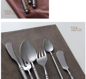 Macro view of matte silver vintage cutlery set with textured handles on fabric