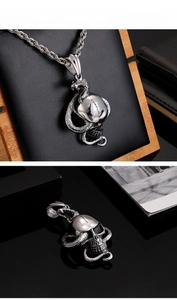 Detailed view of silver punk snake coiled around skull pendant with metallic chain