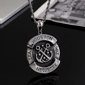 Silver stainless steel anchor and star pendant necklace on a sleek black surface