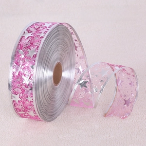 Dettaglio del nastro trasparente rosso rosa con stelle argento e note per decorazioni