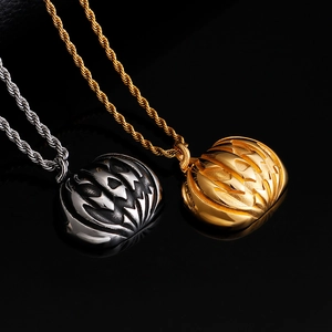 Pendentifs citrouille Halloween en or et argent avec chaînes torsadées sur fond noir