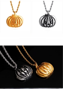 Vue macro des pendentifs citrouille d'Halloween en acier doré et argenté poli