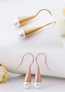 Detailed macro view of elegant shell pearl drop earrings in gold and rose gold finishes