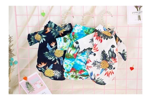 Detailed display of tropical Hawaiian print dog shirts in black, blue and white colors