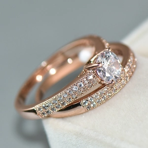 Macro shot of rose gold bridal ring set with six-prong round diamond and pave accents