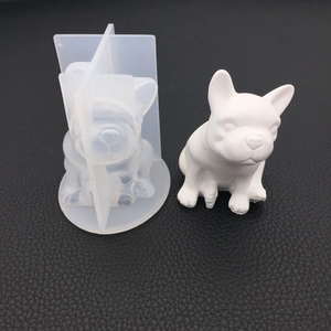 Macro shot of 3D French Bulldog silicone mold and white plaster casting on black surface