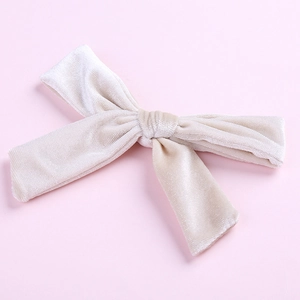 Detail showing soft cream velvet texture and fine fabric of the 5-inch bow hair clip