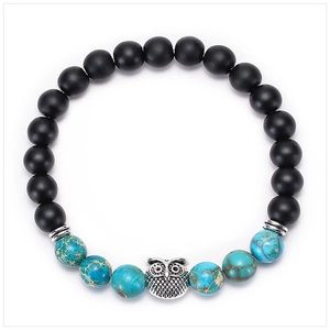 Close-up of matte black beads and blue imperial stone with silver owl charm