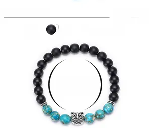 Detail view of 8mm matte beads and emperor stone bracelet with silver owl charm