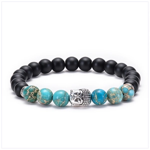 Macro detail of natural blue imperial stone and matte black beads with silver Buddha head