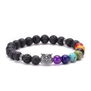 Detail showing lava stone beads with chakra colors and a silver owl charm on a bracelet