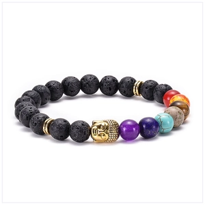 Macro shot of lava stone 7 chakra bracelet with golden Buddha head and porous texture