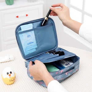 Detail view of blue flamingo cosmetic bag with mesh pocket and brush slots storage