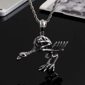 Vintage punk silver crow skull skeleton pendant necklace on a dark reflective background