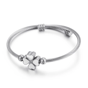 Silver twisted bangle with a clover heart charm on a clean white background