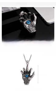 Macro view of devil hand pendant with blue eye and stainless steel dragon claw details