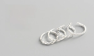 Detail of 4-piece S925 sterling silver ring set showing chain and wave textures