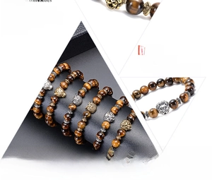 Detailed view of natural tiger eye stone beads with golden lion and owl alloy charms