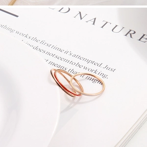 Close-up of three 1mm thin rose gold rings on a white plate with a book background