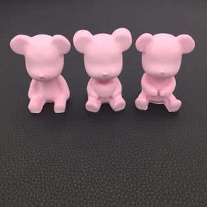 Detailed view of three pink bear-shaped resin molds on a dark textured background